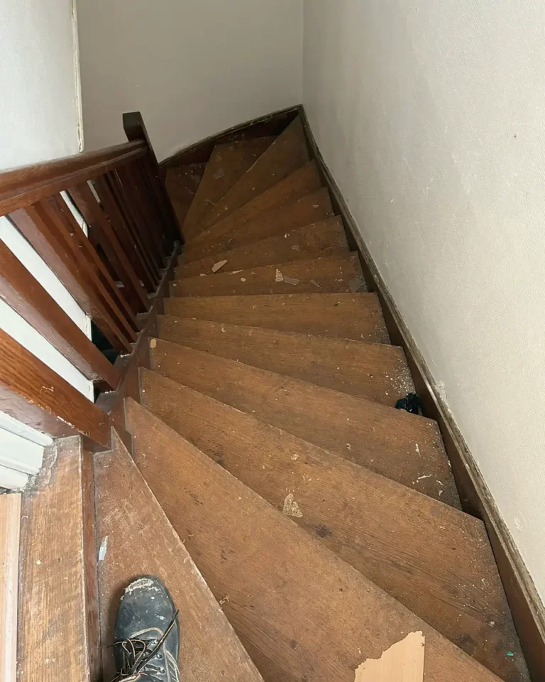 Escalier en bois étroit et tournant qui monte vers un étage, chantier DGE