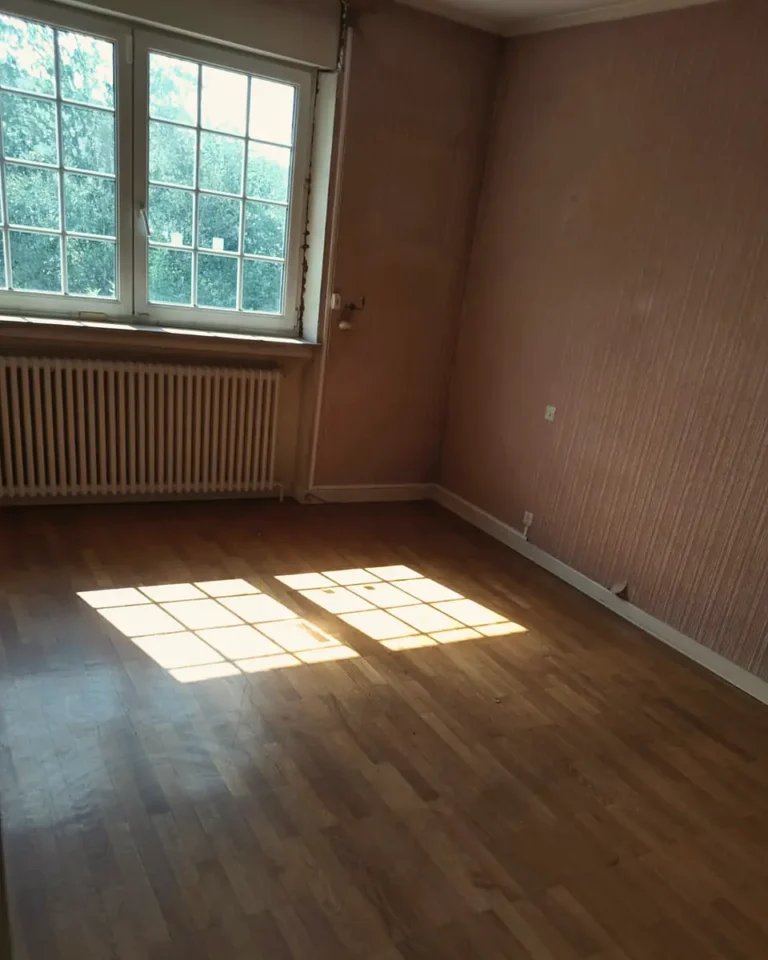 Chambre vidée après un débarras, lumière sur le parquet